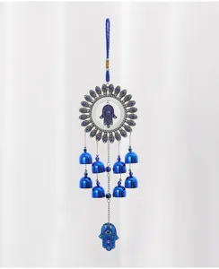 Vista dettagliata del campanello a vento in metallo con occhio turco blu, mano di Hamsa e.