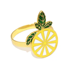 Detailed closeup view of the vibrant yellow enameled lemon napkin ring with green leaf decor.