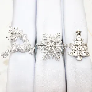 Set of 3 silver Christmas napkin rings featuring reindeer snowflake and tree for holiday table decor.