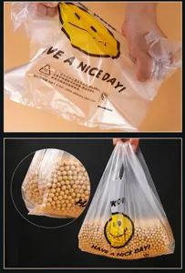 Detail view of transparent plastic grocery vest bag with cute smile face and handle.