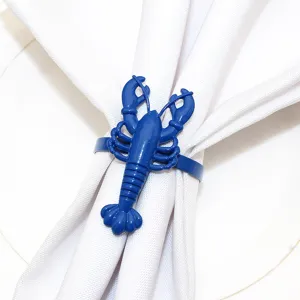 Close-up detail of a vibrant blue lobster napkin ring holding a clean white fabric napkin.