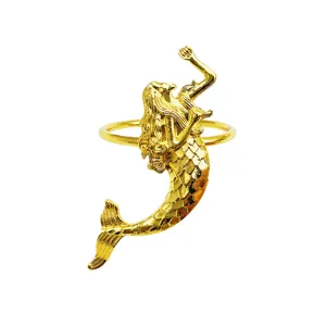 Squisito dettaglio dell'anello portatovagliolo sirena dorata, decorazione tavola.