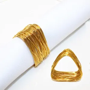 Gold metal wire napkin ring detail, triangular multi-strand wrapped table decor item.