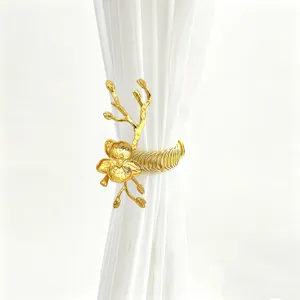 Close-up of luxurious gold orchid curtain tieback, showing metallic flower details and spring design.
