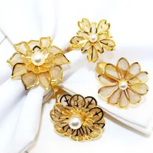 Close-up detail of gold metal napkin rings with floral pearl designs for table decor.