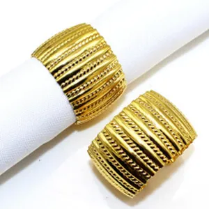 Gold metal napkin ring detail shot, fine leaf textured design for elegant dining decor.