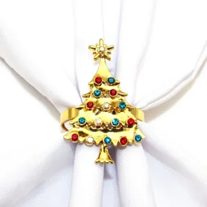 Gold Christmas tree napkin ring detail featuring colorful sparkling rhinestones on white fabric.