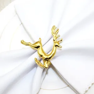 Gold reindeer napkin ring holding white cloth napkin, elegant holiday table decor detail view.