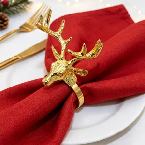 Golden reindeer napkin ring detail, Christmas table setting with red napkin and elegant metal deer.
