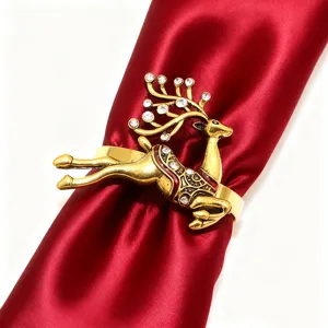 Elegant gold Christmas elk napkin ring with sparkling rhinestones and red satin table decor.