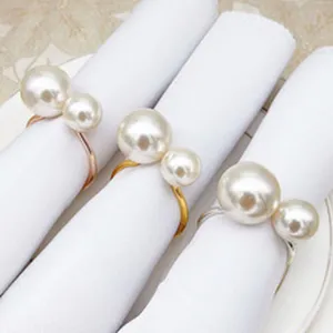 Detail view of elegant pearl napkin rings featuring double faux pearls on metal alloy bands.