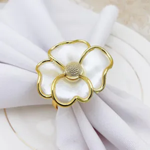 Gold alloy floral napkin ring close-up, elegant table setting detail for hotel dinner decor.