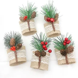 Christmas burlap napkin rings with pine cones and red berries, rustic table decor for holiday party.