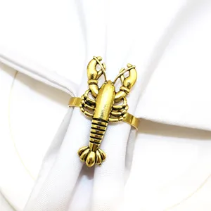 Detailed close-up view of a gold metal lobster napkin ring styled on a clean white table napkin.