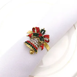 Christmas bell napkin ring detail showing red green rhinestones and bow design on white napkin