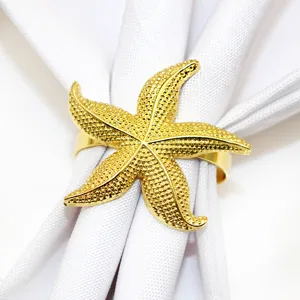 Gold starfish napkin ring close-up detail, elegant ocean table decor for wedding party.