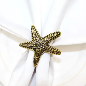 Metal starfish napkin ring for ocean themed table decor, elegant vintage gold finish.