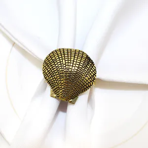 Gold seashell metal napkin ring close up detail for elegant ocean theme table decor