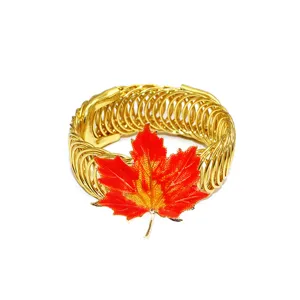 Nahaufnahme des leuchtend orangen Ahornblatts und des goldenen Feder-Vorhanghalters.
