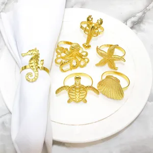 Gold ocean animal napkin rings close up featuring detailed starfish seahorse octopus shell.