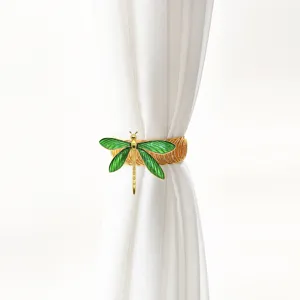Gold metal curtain tieback with green dragonfly design, elegant home decor accessory.