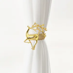 Gold deer curtain buckle detail, metal spring tieback close-up, luxury home decor hardware.
