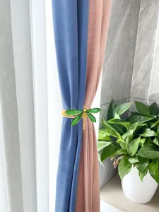 Elegant dragonfly curtain tieback with green enameled wings and metal spring band detail.