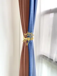 Detailed close-up view of a gold metal reindeer curtain tieback buckle for home decor.