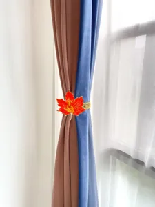 Nahaufnahme der orangen Ahornblatt-Vorhanghalterung mit dekorativem Designdetail.