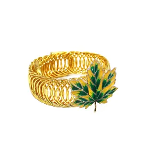 Goldfarbener Metallfeder-Vorhang-Raffhalter mit grün-gelber Emaille-Ahornblattdekoration.