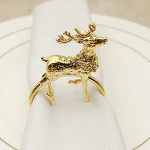 Gold reindeer napkin ring detail, metal Christmas table decor for holiday party setting.