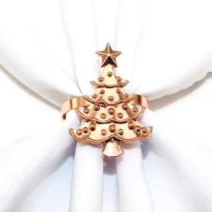 Close-up detail view of elegant rose gold Christmas tree napkin ring on white cloth.