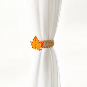 Autumn maple leaf curtain tieback, gold metal spring buckle holding white curtain detail.