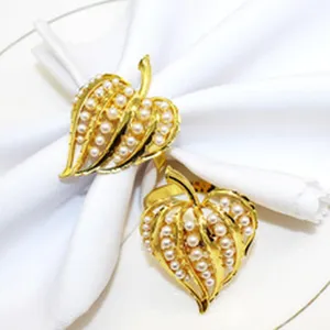 Detail view of gold leaf pearl napkin ring, elegant table decor accessory for hotel and home.