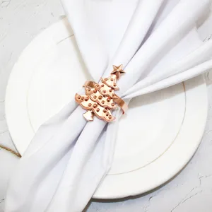Close-up detail of elegant rose gold Christmas tree napkin ring on white napkin.