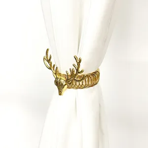 Golden metal deer head curtain tieback detail, elegant spring drapery clip decoration.