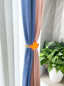 Detail view of the orange maple leaf curtain tieback with a flexible metal spring band for home decor.