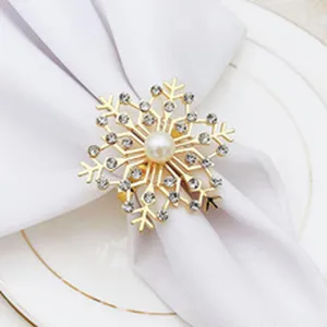 Gold snowflake napkin ring detail featuring sparkling rhinestones and a elegant pearl center.