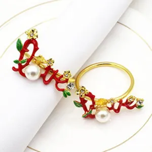 Gold metal napkin ring with red love letters pearl and rhinestone flowers detail shot.