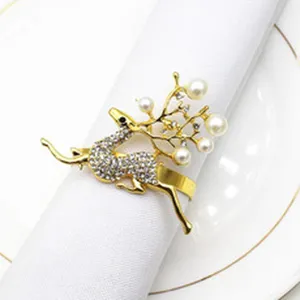 Gold reindeer napkin ring detail, rhinestone crystal and pearl decor for Christmas table.