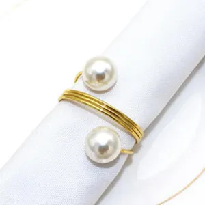 Detailed closeup of the elegant gold alloy napkin ring featuring dual white pearl details.
