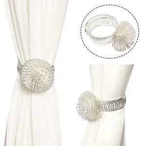 Silver metal curtain tieback with spring wire ball design, elegant window decor accessory.