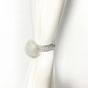 Metal curtain tieback detail with handmade wire ball and spring band for home decor