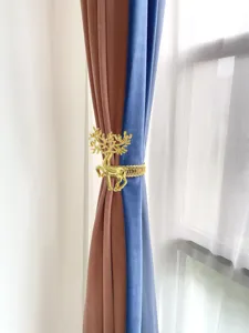 Dettaglio fermatenda cervo dorato, anello elastico in metallo elegante per la decorazione.