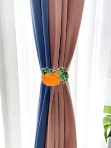 Detail view of the orange rhinestone pumpkin curtain tieback featuring glittering crystal leaves.