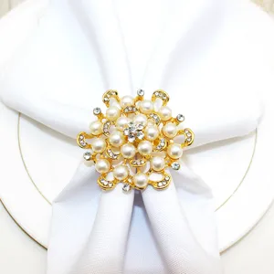 Gold floral napkin ring detail featuring sparkling pearls and rhinestones for elegant table decor.