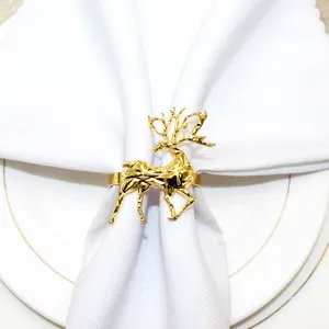 Gold geometric reindeer napkin ring detail, elegant Christmas table decor holding white napkin.