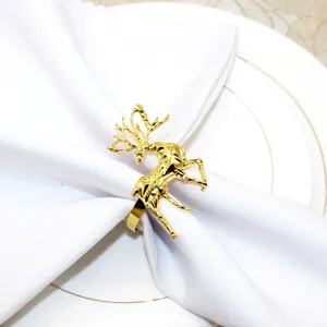 Close-up of the elegant gold geometric reindeer napkin ring on white fabric, detail shot.