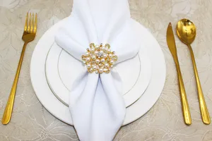 Elegant gold floral pearl and rhinestone napkin ring detail view, perfect for wedding table decor.