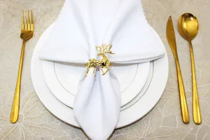 Gold metal reindeer napkin ring close-up view, elegant Christmas table setting decor.